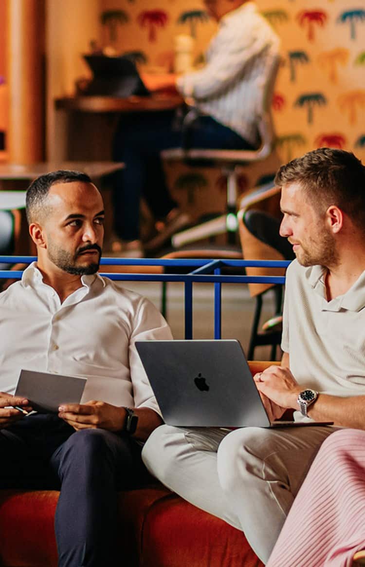 Business professionals discussing office and licensing options in a modern shared workspace.