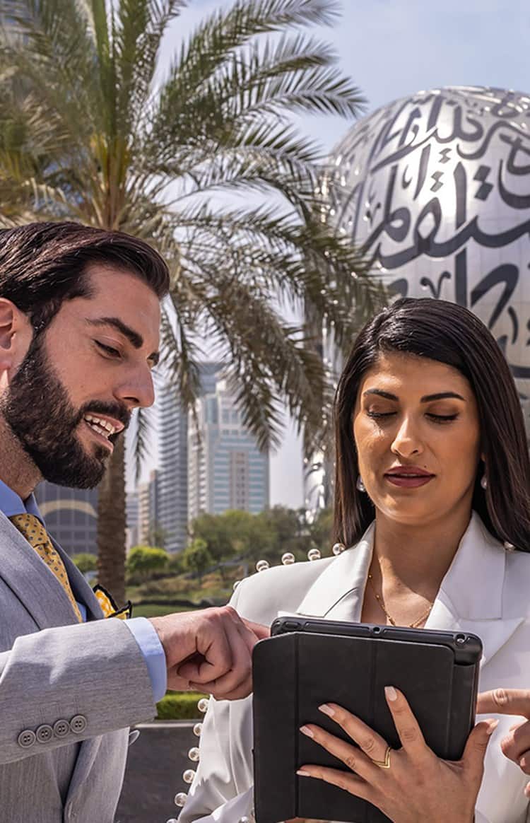 Business professionals discussing a project on a tablet in Dubai