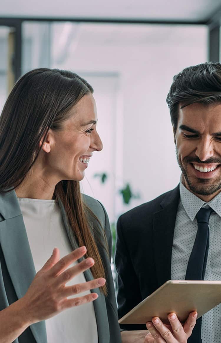 Colleagues discussing work while holding a tablet