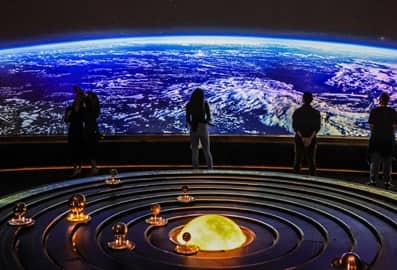 People viewing Earth on a large screen in an immersive exhibition