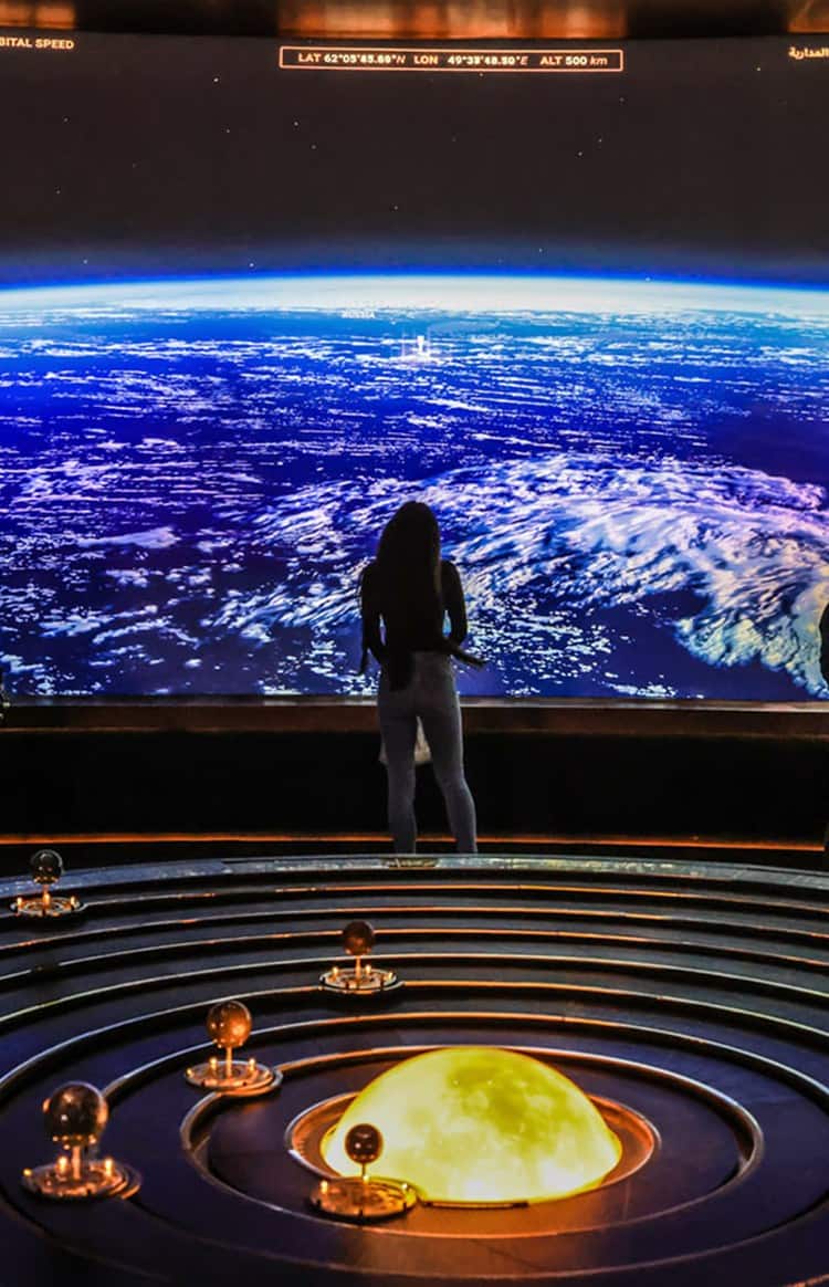 People viewing Earth on a large screen in an immersive exhibition