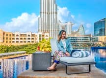 Woman working remotely by a pool overlooking Dubai