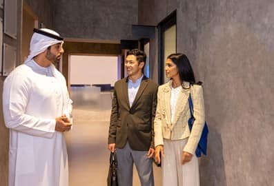 Three colleagues engaged in a discussion inside a modern workplace