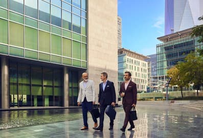 Three colleagues walking through a city business district