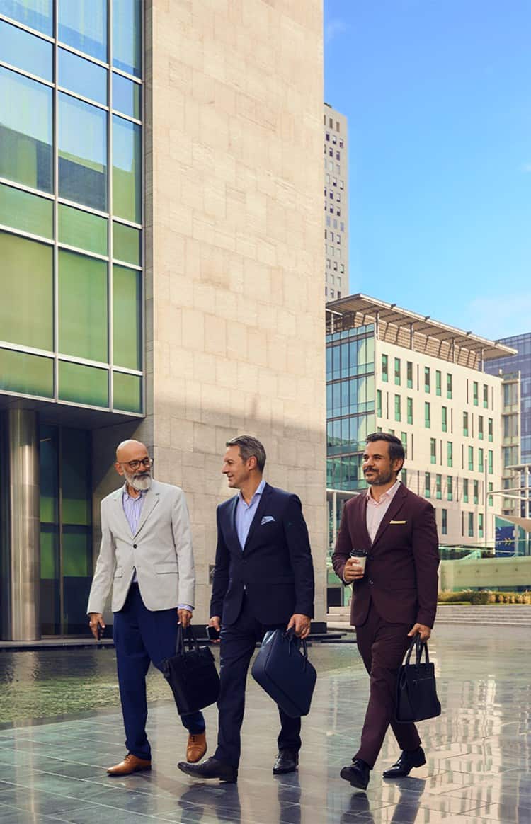 Three colleagues walking through a city business district