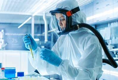 Scientist conducting research in a laboratory wearing protective gear