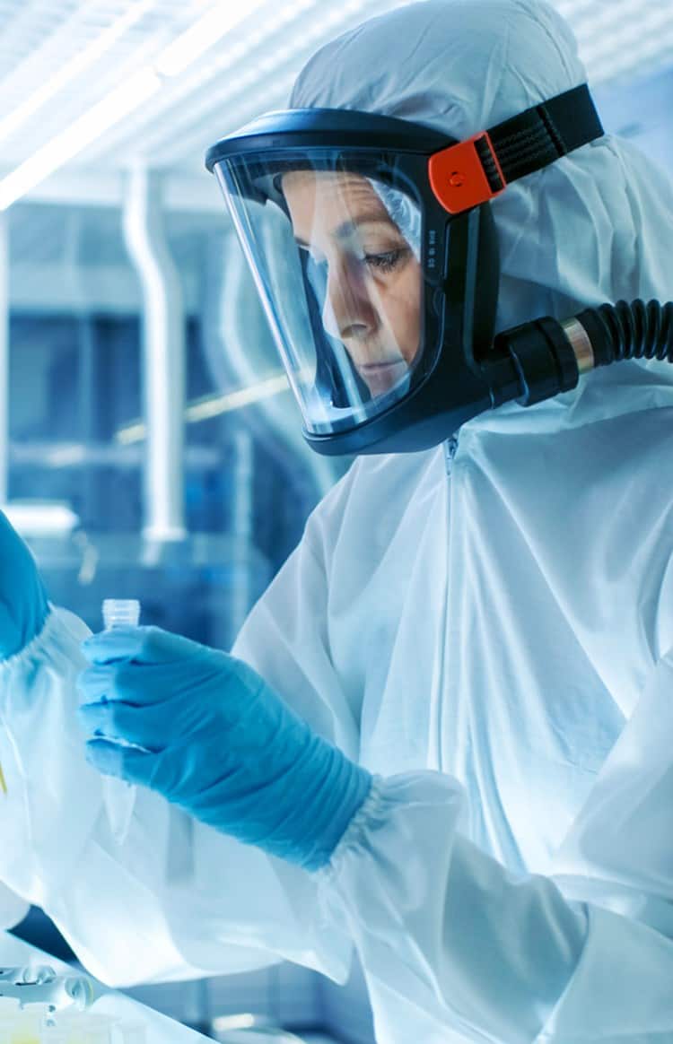 Scientist conducting research in a laboratory wearing protective gear