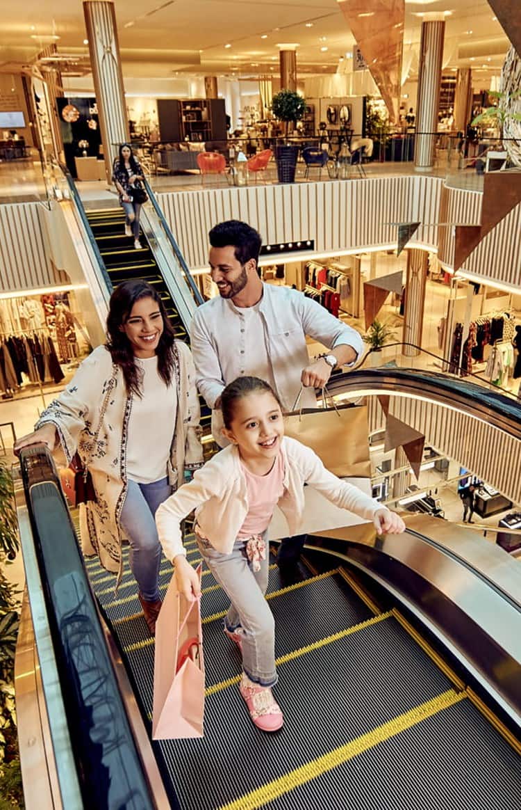 Family riding an escalator inside a modern shopping mall